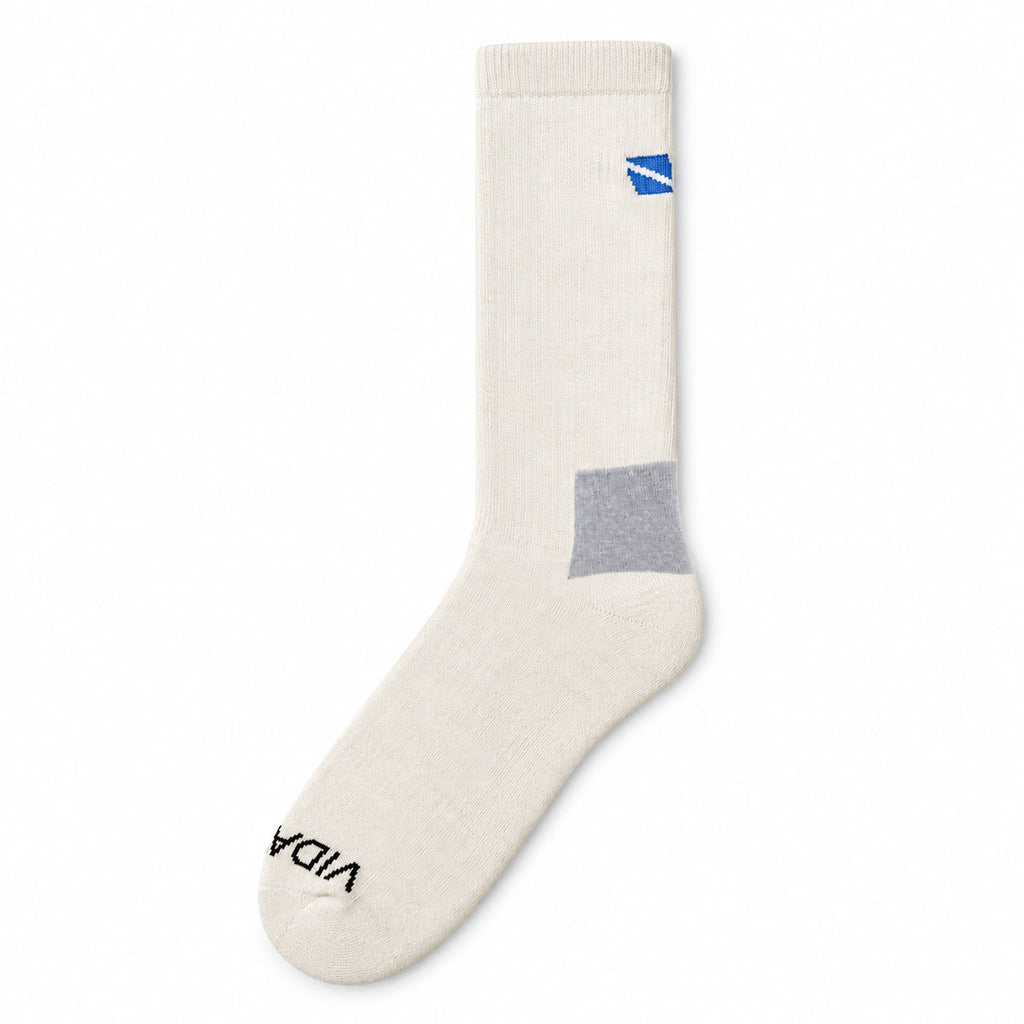 A single off-white crew sock with a gray heel block, a small blue logo near the cuff, and black text near the toe, shown on a plain white background.