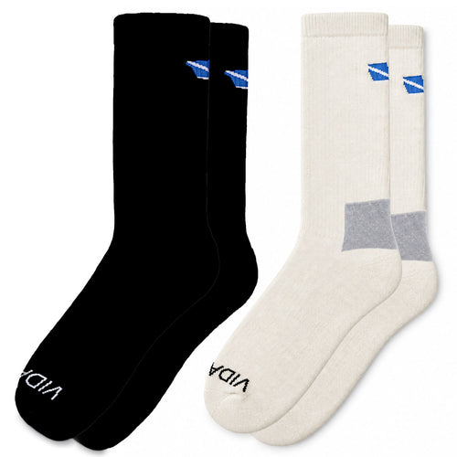 Two pairs of crew socks shown side by side on a white background: one pair is solid black with a small blue logo near the top and white text at the toe, and the other pair is cream/off-white with a gray heel accent and a small blue logo near the top. The brand name 'VIDA' is visible on the toes.